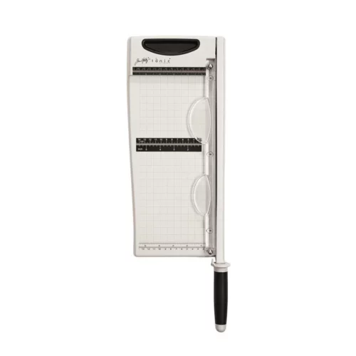 The Tim Holtz Maxi Guillotine Comfort Paper Trimmer has a light grey plastic base with grid marks debossed on the surface. It has a imperial and metric rulers with an extendable base and a geared rotary trimmer arm. The trimmer is rectangular in shape and is shown in the frame at a slight angle on a white background.