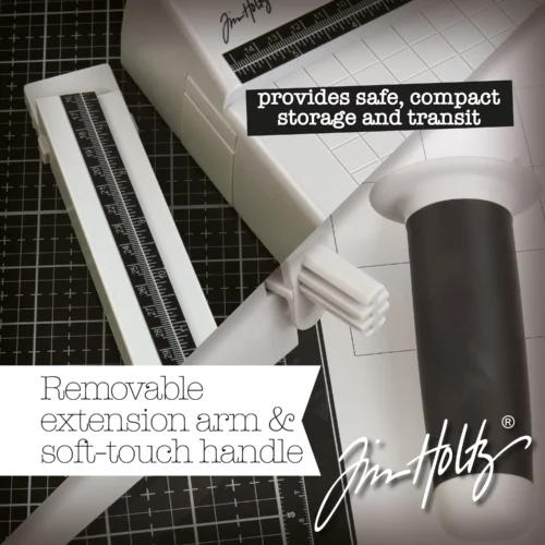 A promotional image for the Tim Holtz Maxi Guillotine Comfort Paper Trimmer. The trimmer has a light grey plastic base and a guillotine arm with a black kushgrip handle for comfort. The Tim Holtz logo is shown in the image. On a dark grey background.