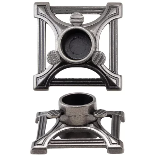 The contents of a pack of Tim Holtz Idea-ology Christmas Tree Stand are shown loose in the frame. There are two metal tree stands, next to each other in the center of the frame. The are silver in colour and are on a white background.