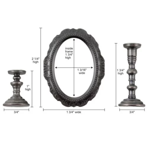 A close up of the contents of a pack of Tim Holtz Idea-ology The Manor. There are two metal candlesticks on either side of the frame and an oval metal frame in the center that is ornate. The candlesticks are also ornate. The candlestick on the left is smaller than the one on the right. There are lines next to the 3 pieces showing the size dimensions of each piece. The image is center of the frame and on a white background.