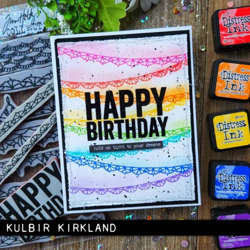 A card made using the Crochet Trims Tim Holtz Stamp Set is shown in the frame. The card is colourful and has the words 'happy birthday' on the front.