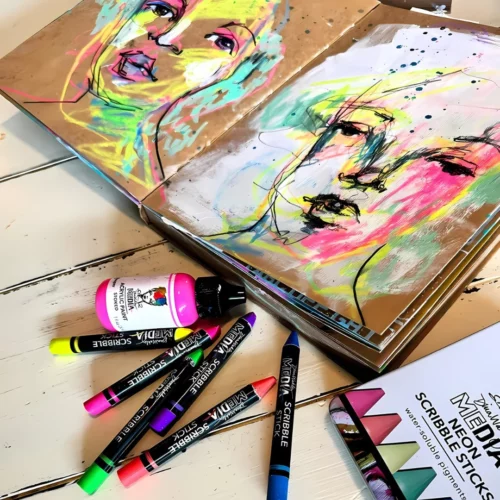 A promotional image for Dina Wakley Media Neon Scribble Sticks. There is a journal in the top of the frame that has drawings of a woman on both pages as the book is open. There are various scribble sticks scattered around the journal and a pink Dina Wakley paint bottle. The image is cut off by the frame.