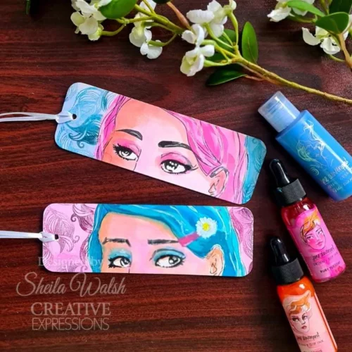 A project, that was made using the Facetime Features Jane Davenport Creative Expressions Clear Stamp Set can be seen in the frame. The image is of 2 tags that have partial faces stamped onto them and coloured in.