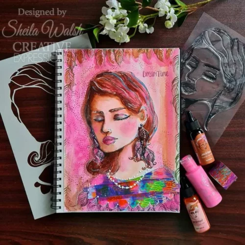 A project, that was made using the Facetime Jane Davenport Creative Expressions Clear Stamp Set can be seen in the frame. The image is of a sketch pad that has a womans face stamped onto it and coloured in with a pink background.