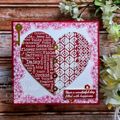 A card is shown in the frame that was made using the Mezzo Woodware Stencil. The background is white and pink and there is a large red heart in the center with the stencil design inside the heart.