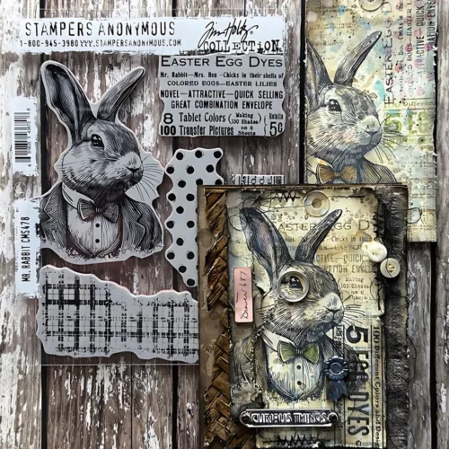 A tag that was made using the Mr Rabbit Tim Holtz Stamp Set is shown in the frame. There is a stamp set behind the card, along the left hand side of the frame.