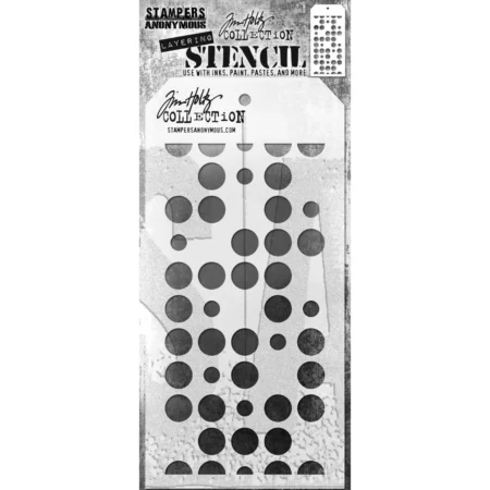 A single Spots Tim Holtz Layering Stencil is seen in the center of the frame in it's packaging. The packaging has a printed backing board with a clear plastic that holds the stencil to the backing board. The backing is printed in grey and has some text at the top of the packaging describing the contents and includes the Tim Holtz logo. You can see the stencil through the clear packaging. The stencil is plastic and tag shaped and the design is cut out from the body of the tag shaped stencil. The image is center of the frame and on a white background.