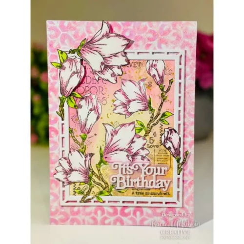 A greeting card that was made using the Spring Magnolia Woodware Clear Stamp Set is shown in the frame. The card is pink and the flowers have been coloured in pink too.