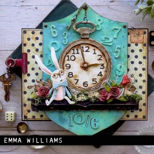 An altered art project was made using the Vault Watch Gears by Tim Holtz Thinlits Die Set. There is a shield shaped piece of cardboard in the center of the frame with a clock watch and a bunny and some flowers embellished on it.