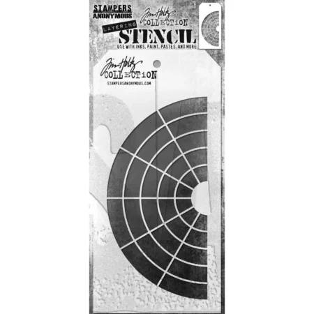 A single Wheel Tim Holtz Layering Stencil is seen in the center of the frame in it's packaging. The packaging has a printed backing board with a clear plastic that holds the stencil to the backing board. The backing is printed in grey and has some text at the top of the packaging describing the contents and includes the Tim Holtz logo. You can see the stencil through the clear packaging. The stencil is plastic and tag shaped and the design is cut out from the body of the tag shaped stencil. The image is center of the frame and on a white background.