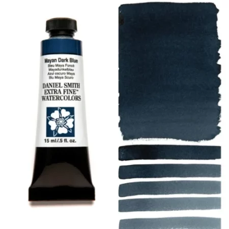 A tube of mayan dark blue Daniel Smith Watercolour Paint is shown in the frame, to the left hand side of the frame vertically. The tube has a black plastic cap and a black base. The center of the tube is white and there is a colour band at the top of the tube, below the cap, that indicates the colour of the paint. There is black text on the front of the tube with the brand name and logo. To the right of the tube is a colour swatch which was made using the paint. In the colour swatch, you can see the paint undiluted and in a diluted form. The image is on a white background and is center of the frame.