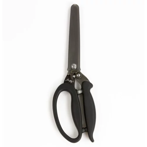 A single pair of Tim Holtz Recoil Scissors can be seen laying vertically in the center of the frame. The scissors have a black plastic handle and a metal blade with a spring between the handles. On a white background.