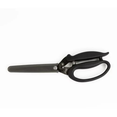A single pair of Tim Holtz Recoil Scissors can be seen laying horizontally in the center of the frame. The scissors have a black plastic handle and a metal blade with a spring between the handles. On a white background.