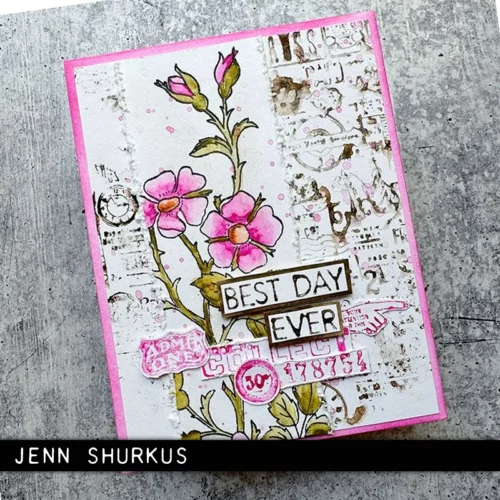 A single card that was made using the Embroidery Tim Holtz Stamp Set is shown in the center of the frame on a faux wooden background. The card is white with flowers stamped on the front that have been coloured in with pinks and reds.