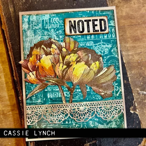 A single card is shown in the center of the frame that was made using the French Garden Tim Holtz Stamp Set. The card is vintage styled and has a blue background with 2 yellow flowers. The image is cut off by the frame.