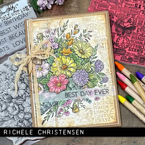 A single card that was made using the Hodgepodge Tim Holtz Stamp Set is shown in the frame. The card has the stamped imagery in the background in a neutral colour and a large bouquet of flowers on top of it that have been coloured in with pastel colours. There is a sentiment on the card. There are a few tim holtz pencils scattered around the card.