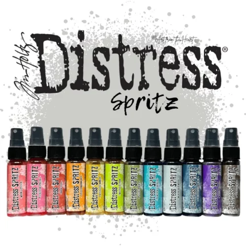 There are 12 bottles of Tim Holtz Distress Spritz shown in the frame. The bottles are a clear plastic with a black plastic spray top and a clear plastic lid. There is a coloured label around the body of each bottle that indicates the colour of the ink. The Distress Logo and product details are printed on the label. The bottles are lined up vertically along the bottom of the frame, with the Tim Holtz Distress logo above the bottles.