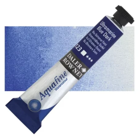 Ultramarine dark Daler Rowney Aquafine Watercolour is sitting horizontally across the image with the lid facing the top right corner. it has a black lid and a blue bottom end. the name of the product is on the top middle of the tube, it is lying across a horizontal strip of the same colour that is in the center of the image. On a white background.