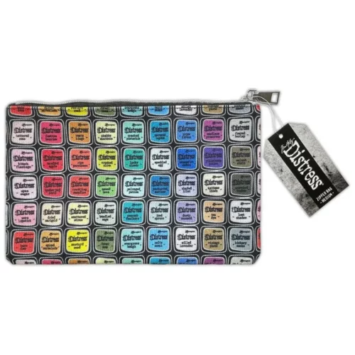 A Tim Holtz Distress Zipper Bag Medium is shown diagonally in the center of the frame. The bag is made of a printed fabric, adorned with colorful artwork from the complete Distress colour palette. The bag has a Distress tag attached to it and it has a metal zipper. On a white background.