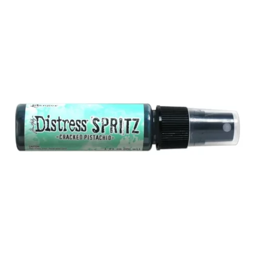 A single bottle of Cracked Pistachio Tim Holtz Distress Spritz is shown laying horizontally in the center of the frame. The bottle is a clear plastic with a black plastic spray top and a clear plastic lid. There is a coloured label around the body of the bottle that indicates the colour of the ink. The Distress Logo and product details are printed on the label. The image is center of the frame and on a white background.